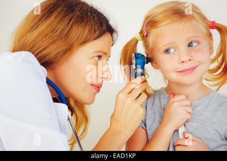 Pediatrician doctor examining little girl`s ears. Stock Photo